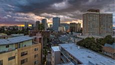 The sun sets over an urban neighborhood.