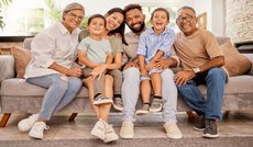 A multigenerational family sits on a couch.